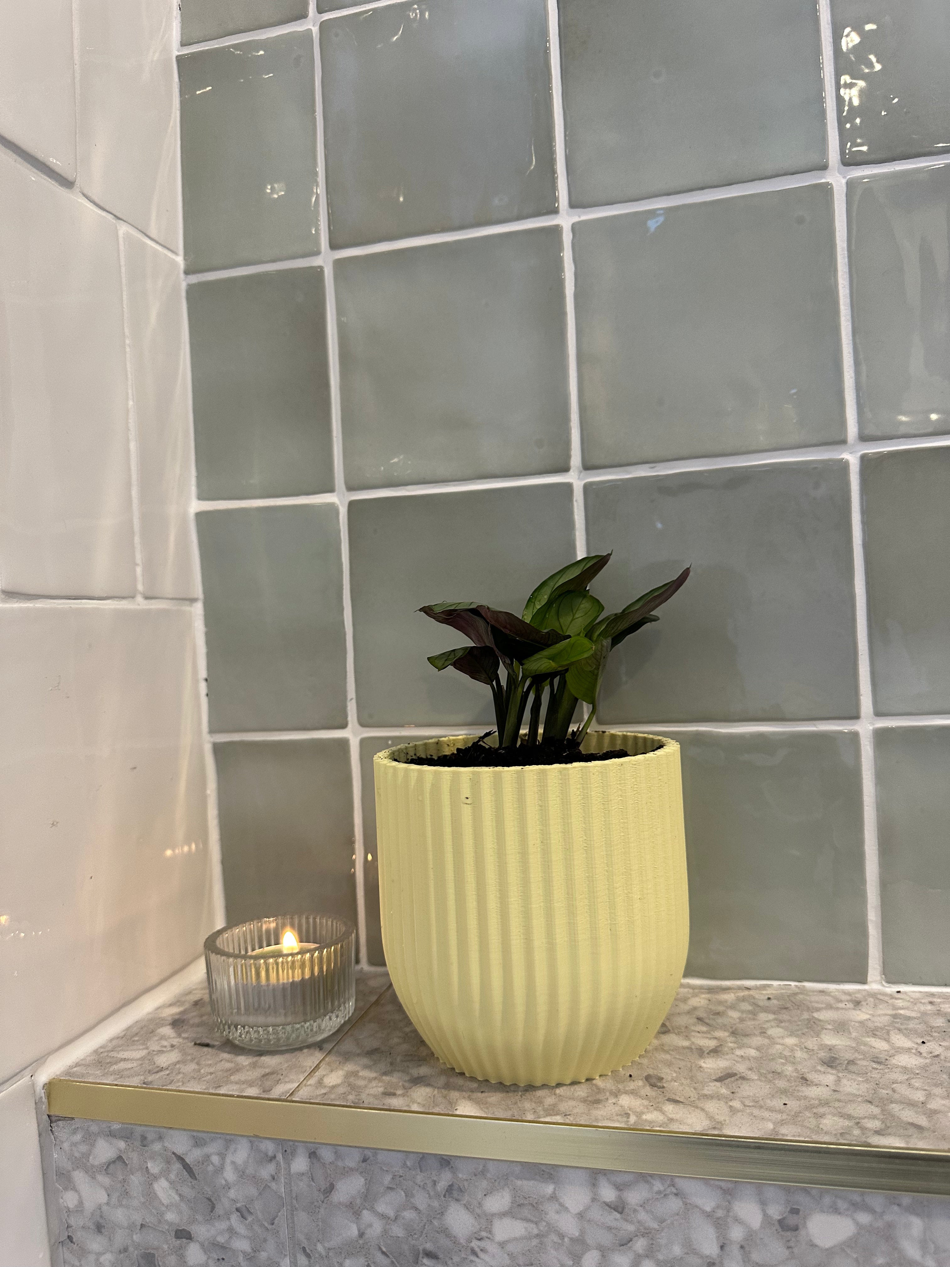 Yellow Rilla planter with plant on tiled surface
