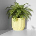 Rilla planter in soft yellow with leafy green plant