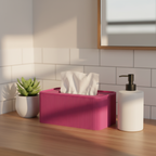 A bright pink ribbed tissue box cover holding white tissues, styled on a wooden countertop next to a white soap dispenser and a small potted succulent in a bathroom setting with white subway tiles and warm sunlight.
