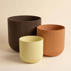 The Forma Trio nesting planter set in Warm Clay — almond yellow, copper and chocolate gradient